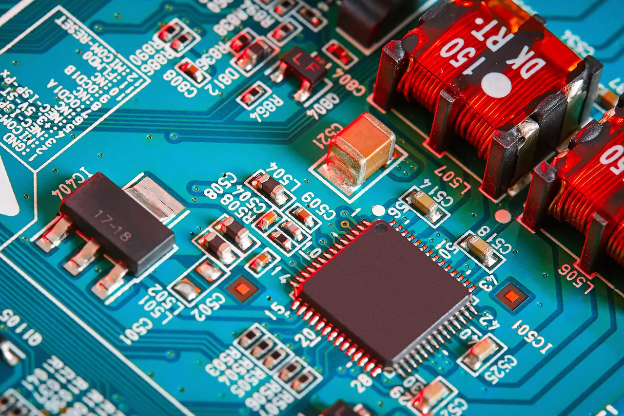 Komponentlerle dizilmiş kırmızı kondansatörlü PCB